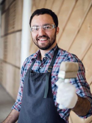 happy-young-painter-holding-paint-brush-and-showing-it-to-camera-768x1154